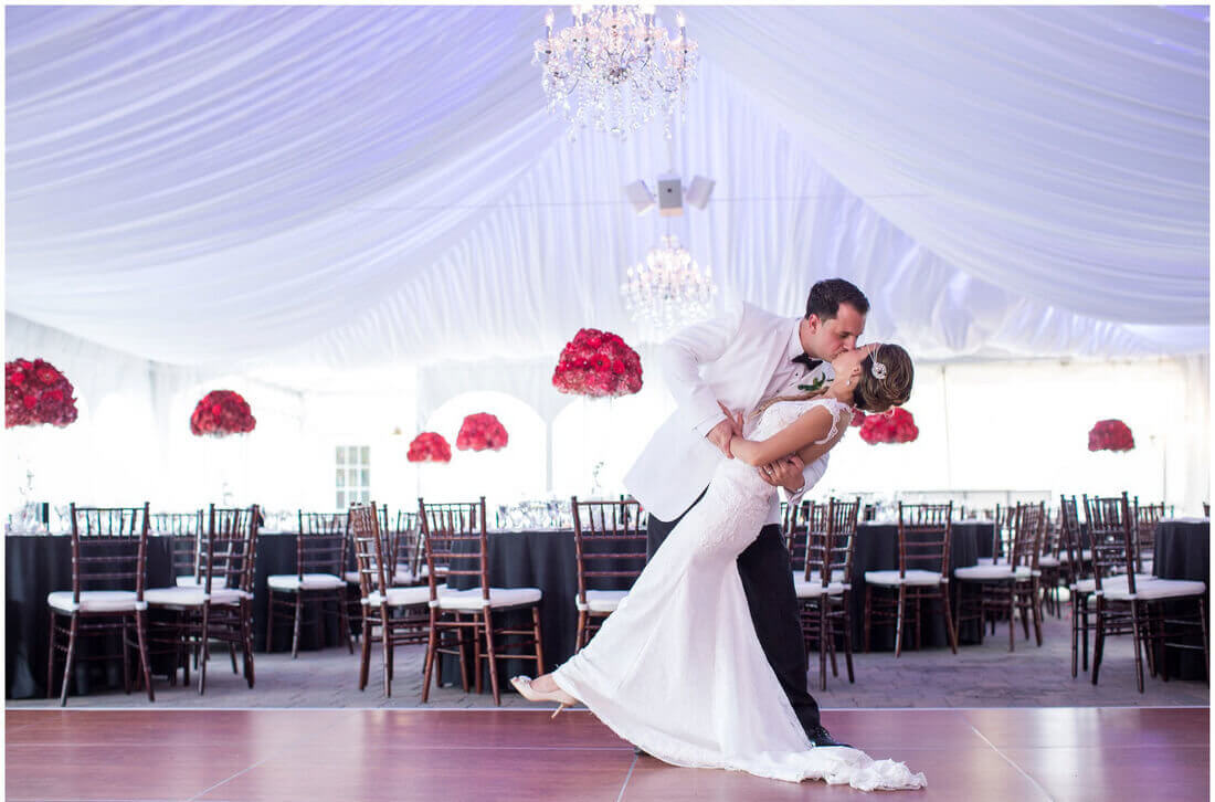bride and groom kissing in tent reception