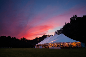 beautiful sunset above an outdoor tent wedding