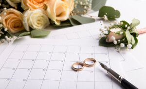 Planning wedding with golden rings on date in calendar