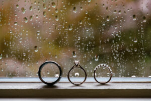 Three wedding rings in front of rainy window